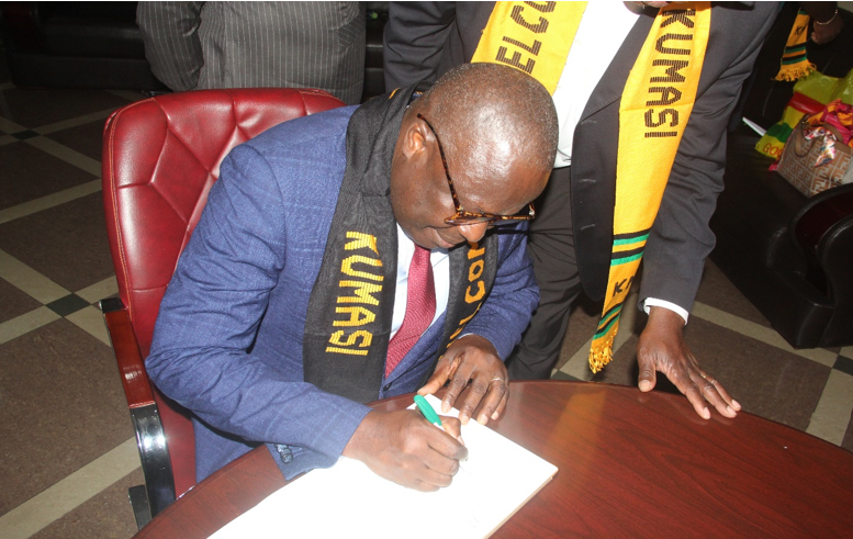 Mayor Gomado Koamy Gbloekpo signing the visitors book at the KMA
