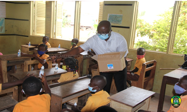 The Kumasi Mayor distributing hand sanitizers to Class One pupils at Fankyenebra MA Primary 